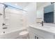 Bright bathroom featuring white cabinets, black hardware, and a shower/tub combo with tile surround at 8648 Cloverbelle St, Las Vegas, NV 89166