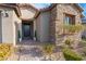 Home exterior with brick pathway and landscaping leading to a dark wooden front door at 8648 Cloverbelle St, Las Vegas, NV 89166