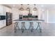 Modern kitchen island with seating, stainless steel appliances, and black countertops at 8648 Cloverbelle St, Las Vegas, NV 89166
