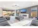 Bright living room featuring a sleek fireplace, large sectional, and access to the outdoor space at 8648 Cloverbelle St, Las Vegas, NV 89166