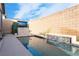 Backyard pool with decorative water feature, lush landscape, and mounted flatscreen TV for outdoor entertainment at 8648 Cloverbelle St, Las Vegas, NV 89166