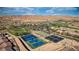 Panoramic aerial view showcasing community tennis courts, lush landscaping, and the desert's natural beauty at 906 Majestic Vw, Mesquite, NV 89034