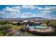 Aerial view of a community clubhouse with a pool, surrounded by lush landscaping and mountain views at 906 Majestic Vw, Mesquite, NV 89034
