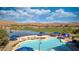 Inviting community pool and hot tub area with comfortable seating, set against a picturesque desert and golf course scenery at 906 Majestic Vw, Mesquite, NV 89034