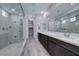 Modern bathroom with dual sinks, a large mirror, wood-style flooring, and a tiled shower at 12397 Foxtail Run Ave, Las Vegas, NV 89138