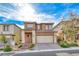 Two-story tan home features a two-car garage and low maintenance desert landscaping at 12397 Foxtail Run Ave, Las Vegas, NV 89138