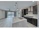 This kitchen features a large island, dark cabinets, stainless appliances, and sliding glass doors to an outdoor area at 12397 Foxtail Run Ave, Las Vegas, NV 89138