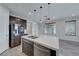 A modern kitchen featuring a large island with a sink, stainless steel appliances, and wood-look tile flooring at 12397 Foxtail Run Ave, Las Vegas, NV 89138