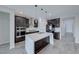 A stylish kitchen with dark cabinets, stainless steel appliances, a large island, and elegant pendant lighting at 12397 Foxtail Run Ave, Las Vegas, NV 89138