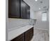 This laundry room features gray cabinets, countertop, and tile floor at 12397 Foxtail Run Ave, Las Vegas, NV 89138