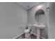 This half bathroom features a decorative mirror and tile flooring at 12397 Foxtail Run Ave, Las Vegas, NV 89138