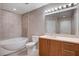 Bathroom featuring a soaking tub, tile surround, and vanity with storage at 200 W Sahara Ave # 3009, Las Vegas, NV 89102