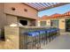 Modern outdoor kitchen with a grill, bar seating, and a pergola at 200 W Sahara Ave # 3009, Las Vegas, NV 89102