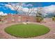 A beautiful community entrance includes stone signage, desert landscaping, and mature trees at 2386 Amana Dr, Henderson, NV 89044