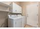Laundry room with a white washer, dryer, and storage cabinets at 2386 Amana Dr, Henderson, NV 89044