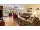 Comfortable living room featuring a ceiling fan, large windows, tile flooring, and ample seating space at 2386 Amana Dr, Henderson, NV 89044