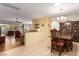 Open-concept living room and dining area with tile floors, neutral paint, and plenty of natural light at 2386 Amana Dr, Henderson, NV 89044