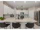 Modern kitchen featuring white cabinets, sleek stainless steel appliances, and a large island with barstool seating at 2475 Piacenza Pl, Henderson, NV 89044