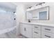 Modern bathroom with large mirror, white cabinets, and a walk-in shower featuring marble-look tile at 2553 Showcase Dr, Las Vegas, NV 89134