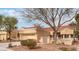 Single-story home with a tan exterior, tile roof, front yard landscaping, and a two-car garage at 2553 Showcase Dr, Las Vegas, NV 89134