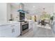 Staged kitchen featuring white cabinets, a stainless steel oven, modern appliances, and wood grain floors at 2553 Showcase Dr, Las Vegas, NV 89134