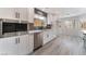 Well-lit kitchen with white cabinets, stainless appliances, modern fixtures, and wood-look flooring at 2553 Showcase Dr, Las Vegas, NV 89134
