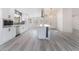 Bright kitchen featuring white cabinets, an island with seating, wood grain floors, and modern appliances at 2553 Showcase Dr, Las Vegas, NV 89134