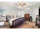 Cozy bedroom featuring warm hardwood floors, a comfortable bed, natural light, and a ceiling fan at 2768 Tyndrum Ave, Henderson, NV 89044