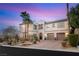 Inviting two-story home with a paved driveway, lush landscaping, and a charming entrance featuring double garage doors at 2768 Tyndrum Ave, Henderson, NV 89044