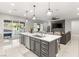 Modern kitchen with island seating, stainless steel appliances, and access to the outdoor patio at 2768 Tyndrum Ave, Henderson, NV 89044