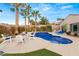 Stunning backyard pool area featuring a unique design, multiple seating options, and a lush green landscape at 2768 Tyndrum Ave, Henderson, NV 89044