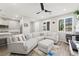 Bright living room featuring a comfortable white sectional sofa, ceiling fan, and wood-look floors at 2816 Turnstone Ridge St, Henderson, NV 89044