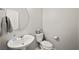 Clean powder room features a pedestal sink, round mirror and toilet at 2816 Turnstone Ridge St, Henderson, NV 89044