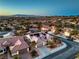Property featuring well-maintained landscaping in a neighborhood near mountains during an evening sunset at 3002 Hickory Valley Rd, Henderson, NV 89052