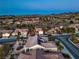 High-angle aerial showing the tile roof of the home, landscaping, a desert landscape and nearby homes in a residential neighborhood at 3002 Hickory Valley Rd, Henderson, NV 89052