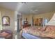 Serene main bedroom with a four-poster bed, side chair, and neutral color scheme at 3002 Hickory Valley Rd, Henderson, NV 89052