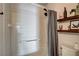 Bright bathroom featuring a shower/tub combo with white tile surround, complemented by decorative shelves at 3313 Jamaica Princess Pl # 3, North Las Vegas, NV 89084