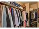 Organized closet with a variety of clothing items on hangers and storage bins on the upper shelves at 3313 Jamaica Princess Pl # 3, North Las Vegas, NV 89084