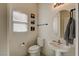 Bright powder room with pedestal sink, stylish fixtures, decorative art, and modern toilet at 3313 Jamaica Princess Pl # 3, North Las Vegas, NV 89084