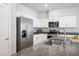 Modern kitchen featuring stainless steel appliances, white cabinetry, and granite countertops at 3807 Andorian Ave, North Las Vegas, NV 89084