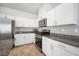 Modern kitchen featuring stainless steel appliances, white cabinetry, and granite countertops at 3807 Andorian Ave, North Las Vegas, NV 89084