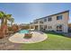 Beautiful backyard featuring a sparkling pool, rock waterfall, fire pit, and landscaped yard at 3892 Pasilla Ave, Las Vegas, NV 89118
