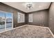 This bedroom features dark gray walls, and multiple windows with plantation shutters, and a sliding glass door at 3892 Pasilla Ave, Las Vegas, NV 89118