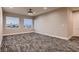 Bright neutral bedroom featuring patterned carpet and city views from two large windows at 3892 Pasilla Ave, Las Vegas, NV 89118