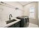 Well-appointed laundry room with stainless steel appliances, utility sink, and ample storage at 3892 Pasilla Ave, Las Vegas, NV 89118
