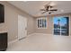 Bright living room with neutral colors, ceiling fan, white door, and a sliding glass door to the outside patio at 3892 Pasilla Ave, Las Vegas, NV 89118
