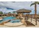 Tranquil pool area featuring a tiki bar, rock waterfall, and spa offers a relaxing backyard escape at 3892 Pasilla Ave, Las Vegas, NV 89118