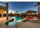 Stunning pool at dusk, complete with rock waterfall, tiki hut, and ambient lighting at 3892 Pasilla Ave, Las Vegas, NV 89118