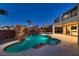 Captivating evening shot of the pool area, showcasing the rock waterfall and elegant lighting at 3892 Pasilla Ave, Las Vegas, NV 89118
