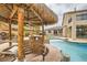 Backyard oasis featuring a pool with rock accents, covered tiki bar, and lush landscaping at 3892 Pasilla Ave, Las Vegas, NV 89118